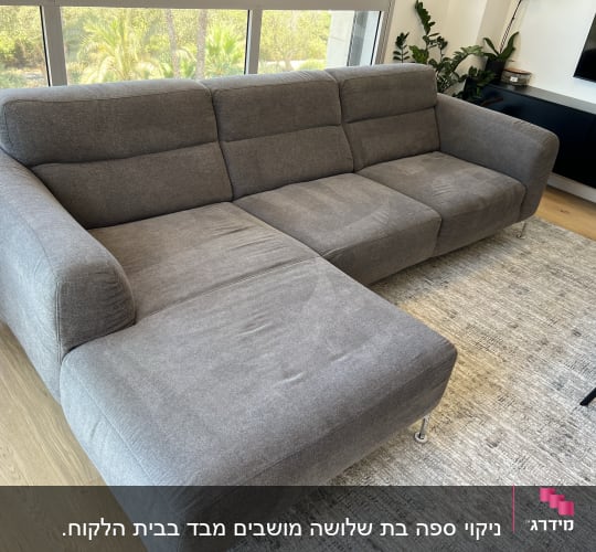 ספה אפורה גדולה עם ריפוד בד בחדר מגורים